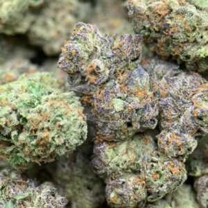 Close-up of White Gumbo THCa Flower buds with frosty trichomes and green leaves.